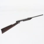 Carabina de ar comprimido Stella. Arma longa com coronha em madeira de formato retilíneo, unida a estrutura metálica tubular e cano liso prolongado. Apresenta mecanismo de articulação do cano para armamento, característico das carabinas de ar comprimido. Corpo metálico com acabamento escurecido e marcação em relevo STELLA na região do bloco da culatra. Conjunto composto por gatilho protegido por arco metálico, câmara de compressão cilíndrica e sistema articulado para carregamento mediante inclinação do cano. Empunhadura posterior em madeira maciça, fixada por rebites à estrutura metálica. Fabricada pela Indústria Brasileira de Material Bélico  IMBEL / Rossi, sob a denominação comercial Stella, destinada ao uso com projéteis de chumbo tipo diabolo para carabina de pressão, usualmente no calibre 4,5 mm (.177). Medida: Comp.: 89 cm.