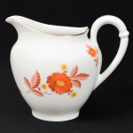 Jean Haviland, Limoges - França. Belíssima leiteira executada em porcelana francesa da década de 1950/60; esmaltagem vítrea na cor branca, bojo oval assente sobre base circular, dotada de decoração em estampagem policromada, composta por ramagens florais estilizadas, predominando as tonalidades coral, marsala e amarelo, bordas contornada por friso em douradura, alça lateral em voluta com anel intermediário, bico vertedor ondulado e revirado para fora. Marca da manufatura no verso. Medidas: Alt.: 11 x Comp.: 11 x Larg.: 10 cm.