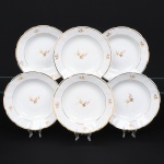 Porcelana Rio Branco/Cia. Brasileira de Vidros, Rio de Janeiro - RJ(Fundada em 1947, ativa até 1967). Conjunto de pratos fundos em porcelana nacional da década de 1950; esmaltagem vítrea na cor branca, dotada de decoração em estampagem policromada, com padrão de flores predominando as tonalidades rosa, amarelo, castanho e cinza, aba circundada com leve movimento ondulatório modelado na própria pasta, borda recortada contornada por friso em douradura. Marca da manufatura no verso. Composto de seis(06) unidades. Medida: Diam.: 23 cm. Apresentam marcas de uso, vide foto.