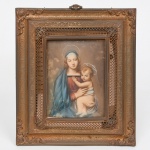 Pequena placa devocional reproduzindo a Virgem Maria com o Menino Jesus, executadam em esmaltes sobre celulóide; inspirada na tradição pictórica renascentista associada às Madonas de Raphael. A imagem apresenta a Virgem em busto, com véu e auréola, sustentando o Menino, ambos com halos estilizado; composição encontra-se protegida por moldura decorativa em metal dourado com elementos vazados e motivos vegetalistas, típica de placas devocionais produzidas para uso doméstico. Verso dotado de fecho metálico com inscrição Brevettato, termo italiano indicando patente registrada, comum em suportes e molduras produzidos na Itália para objetos religiosos. Medidas: Alt.: 20 x Comp.: 17 cm.