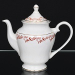 Porcelana Rio Branco/Cia. Brasileira de Vidros, Rio de Janeiro - RJ(Fundada em 1947, ativa até 1967). Elegante bule para café executado em porcelana nacional da década de 1950/50, executado ao estilo francês do período Luís XV; esmaltagem vítrea na cor branca, decoração em esmalte vermelho-coral, formada por arabescos e ramos vegetalistas estilizados, realçada com filetes em douradura; corpo de perfil balaústre assentado sobre base circular, boca ligeiramente revirada para fora, bico vertedor curvilíneo, alça lateral em voluta, tampa campaniforme encimada por puxador ovoide. Marca da manufatura no verso. Apresenta um bicado na borda da boca. Medidas: Alt.: 17,5 x Comp.: 19 x Larg.: 11 cm.