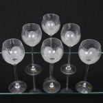 Conjunto taças de pé alto, para vinho branco, executadas em fino cristal europeu, diáfano e incolor; bojo globular, fundo preenchido e talhado com flor acetinada, fuste tubular alongado sobre base circular. Composto de seis(06) unidades. Medidas: Alt.: 25 x Diam.: 8 cm.