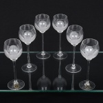 Conjunto taças de pé alto, para vinho do Porto, executadas em fino cristal europeu, diáfano e incolor; bojo globular, fundo preenchido e talhado com flor acetinada, fuste tubular alongado sobre base circular. Composto de seis(06) unidades. Medidas: Alt.: 16,5 x 6 cm;