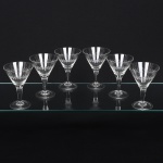 Elegante conjunto de taças de pé alto, para martini, em cristal, diáfano e incolor, bojo obcônico lapidado com sucessão de navetes dispostas horizontalmente, fuste cilíndrico sobre base circular. Composto de seis(06) unidades. Medidas: Alt.: x Diam.: