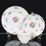 ROYAL TUSCAN - R H & S L Plant, Longton - Inglaterra(Fundada em 1898 / ativa até 1966). Belíssimo trio para chá em porcelana inglesa da década de 1940; esmaltação na cor branca, bojo hemisférico assentado sobre base circular, alça lateral modelada em voluta; decorada com pequenos ramos florais policromos distribuídos internamente, representando flores estilizadas em tons de rosa, azul, amarelo e lilás, acompanhadas por delicadas folhas verdes, aplicadas em estampagem, contornos realçado por filetes em douradura, aplicados na borda da xícara, do pires e do prato, onde também se replicam o padrão decorativo. Marca da manufatura no verso. Medidas: Xícara: ; Pires: ; Prato: