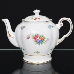 ROYAL TUSCAN - R H & S L Plant, Longton - Inglaterra(Fundada em 1898 / ativa até 1966). Belíssima leiteira inglesa, da década de 1940, executada em porcelana, esmaltação vítrea na cor branca, bojo globular modelado com relevos simulando pétalas, dotada de decoração com motivo floral em estampagem policromada, predominando as tonalidades rosa, verde, azul e violeta, contornos ornamentados com filete em douradura, tampa ligeiramente abaulada encimada por puxador com feitio de pião, bico vertedouro curvado, alça lateral modelada em voluta.. Marca da manufatura ao fundo. Medidas: Alt.:  x Comp.:  x Larg.:  cm.