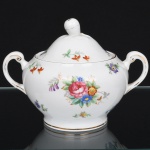 ROYAL TUSCAN - R H & S L Plant, Longton - Inglaterra(Fundada em 1898 / ativa até 1966). Belíssimo açucareiro inglês, da década de 1940, executada em porcelana, esmaltação vítrea na cor branca, bojo aproximadamente elisoide assentado sobre base circular, dotada de decoração motivo floral em estampagem policromada, predominando as tonalidades rosa, verde, azul e violeta, contornos arrematados com friso em douradura, alças laterais modeladas em voluta, tampa abaulada encimada por puxador com feitio de fruto. Marca da manufatura ao fundo. Medidas: Alt.:  x Comp.:   x Larg.:   cm.