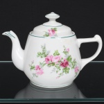 Porcelana Real, Mauá - SP(Fundada em 1943 por Fritz Erwin Schmidt). Bule para chá em porcelana da década de 1950; esmaltação branca vitrificada, corpo bojudo, bico vertedor curvilíneo e alça lateral moldada em voluta estilizada, acompanhada de tampa com pegador central; decoração composta por motivos florais policromados com flores em tonalidades de rosa e folhagens em verde, aplicados sobre o esmalte branco em composição centra replicada na tampa, realçado com filetes em verde nos bordos e no bico vertedor. Marca da manufatura no verso. Medidas: