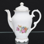Porcelana Real, Mauá - SP(Fundada em 1943 por Fritz Erwin Schmidt). Bule para café em porcelana nacional, esmaltação branca, decorada com composição floral em estampagem policromada aplicada na porção inferior, bordas e contornos realçados com filete dourado; bojo oval alongado sobre base recortada, bico vertedor curvado, alça lateral em voluta, tampa ligeiramente abaulada sob pega em forma de botão. Marca da manufatura ao fundo. Medidas: