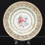 Paragon China Company(antes Star China Company funda em 1897). Prato de serviço em faiança inglesa, formato circular com aba larga; campo central decorado com composição floral policromada, representando rosas e flores campestres, executada em pintura sob esmalte; aba ornada com friso contínuo em douração, composto por motivos fitomorfos estilizados e elementos ornamentais repetitivos; filetes dourados delimitando reservas concêntricas. Decoração realizada por transferência e acabamento manual em douração. Marca da manufatura no verso. Medida: Diam.: