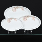 Porcelana Real, Mauá - SP(Fundada em 1943 por Fritz Erwin Schmidt). Três(03) travessa ovais em porcelana nacional, esmaltação na cor branca, decoração com arranjos florais em tonalidades suaves de rosa, acompanhadas por folhas em verde claro, dispostos lateralmente na aba, complementado por filetes dourados finos aplicados próximos à borda e na linha interna da aba. Marca da manufatura no verso. Medidas: Comp.: x Larg.: ; Comp.: x Larg.: ; Comp.: x Larg.: