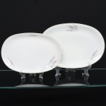 Porcelana Renner, Porto Alegre - RS(Fundada em 1937). Duas(02) travessa ovais em porcelana nacional, esmaltagem vítrea na cor branca, decorado com flores estilizadas em estampagem policromada, orla delimitada por friso em douradura. Medidas: Comp.: x Larg.: ; Comp.: x Larg.: