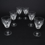 Conjunto de taças para licor em cristal, bojo talhado com lapidação geométrica composta por motivos losangulares, fuste tubular sobre base circular. Composto de seis(06) unidades. Medidas: