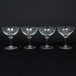 Conjunto de taças para champanhe em cristal, diáfano e incolor; bojo hemisférico talhado com padrão flores estilizadas, fuste tubular sobre base circular. Composto de quatro(04) unidades. Medidas: