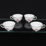 Porcelana Real, Mauá - SP(Fundada em 1943 por Fritz Erwin Schmidt). Quatro(04) xícaras para chá(sem pires) em porcelana nacional, esmaltação branca modelada com frisos e volutas em relevo; bojo decorado com composição floral em estampagem policromada, predominando as tonalidades rosa e ocre, bordas contornada por friso em douradura, alça lateral em voluta. Marca da manufatura ao fundo. Medidas: Alt.: x Diam.: