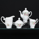 Porcelana Real, Mauá - SP(Fundada em 1943 por Fritz Erwin Schmidt). Conjunto em porcelana nacional, esmaltação branca modelada com gomos em relevo; bojo decorado com composição floral em estampagem policromada, predominando as tonalidades rosa e verde, bordas e contornos realçados com friso em douradura, alças laterais em voluta, bico vertedor ondulado e curvilíneo, e pega da tampa ovoide. Composto de um(01) bule para café, uma(01) leiteira, uma(01) cremeira e um(01) açucareiro. Marca da manufatura ao fundo. Medidas: