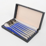 Conjunto composto por seis(06) colheres de cabo alongado em metal prateado, com concha oval e cabos decorados em relevo com motivos rocaille, acondicionadas em estojo original forrado internamente. Medida: