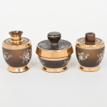 Conjunto de toucador composto por dois(02) frascos(sem tampa) e um(01) pote com tampa em vidro fosco, decoração em pintura esmaltada com motivos florais e faixas em douradura. Estado conforme fotografias. Medidas: 