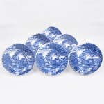 Johnson Brothers, Staffordshire - Inglaterra(Fundada em 1883). Belíssimo conjunto de pratos rasos executado em faiança inglesa, padrão Watermill. Decoração monocromática em azul sob esmalte, representando paisagem rural com moinho hidráulico, executada por estampagem. A composição mostra edifício de moinho com roda dágua em funcionamento, pequeno dique e queda d'água, acompanhados por casas campestres, árvores frondosas, figuras humanas em ambiente bucólico e céu anuviado ao fundo; orla modelada com delicado movimento ondulado, borda recortada com arcos em repetição. Marca da manufatura no verso. Composto de seis(06) unidades. Medida: Diam.: 25 cm.
