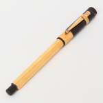 Caneta tinteiro de coleção, corpo em material sintético de tonalidade preta, com revestimento e clipe lateral metálico espessurado à ouro , de perfil facetado. Pena metálica com inscrição MABIE TODD & Co, com respiro cordiforme. Sistema de enchimento por conta-gotas (eyedropper). Produção inglesa, Mabie Todd & Co., início do século XX, circa 19101925.