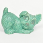 Escultura representando cão em cerâmica inglesa, superfície com vidrado monocromático em tonalidade verde-turquesa, de aspecto salpicado. Base com orifício de ventilação e inscrição MADE IN ENGLAND e numeração 1646. Medidas: