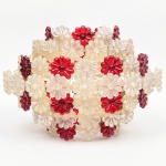 Plafon / luminária de teto em material plástico moldado. Estrutura composta por aros concêntricos em material plástico translúcido, interligados por elementos de fixação metálicos. Superfície externa integralmente revestida por módulos florais aplicados, em plástico moldado, alternando peças translúcidas incolores e peças em tom vermelho. Composição em padrão repetitivo, formando volume esférico aberto. Elementos estruturais internos em metal, com suportes para fixação ao ponto de luz. Produção provável da década de 1960-1970. Estado conforme fotografias. Medidas: