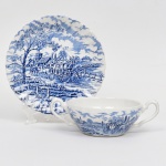 Myott, Staffordshire - Inglaterra. Xícara para consommé em faiança fina inglesa, decoração transfer-printed, padrão Royal Mail; esmaltação branca, decoração figurativa com cena campestre, incluindo carruagem tracionada por cavalos, edificações rurais, elementos arbóreos e cercas, distribuída em registro contínuo na xícara e em campo central no pires. Borda do pires modelada com contorno ondulado. Marca da manufatura no verso. Medidas: