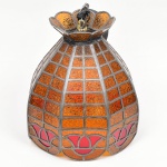 Cúpula de luminária em vidro texturizado com armação metálica, técnica de vitral com solda; corpo em forma de campânula com painéis em vidro em tonalidade âmbar e elementos em vermelho, estrutura em perfis metálicos formando reticulado, friso inferior com composição estilizada de flor de lótus, borda superior recortada com encaixe para soquete. Medidas: