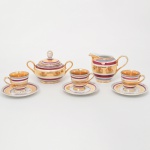 Conjunto em porcelana, manufatura OPAL, composto de um(01) açucareiro, uma(01) leiteira e três(03) xícaras para café, dotados de rica decoração com faixas concêntricas nas cores vinho e lilás, intercaladas por reservas amplas com douração integral (ouro aplicado). Interior das xícaras igualmente dourado. Apresentam desgastes visíveis nas fotografias. Marca da manufatura ao fundo. Medidas: Açucareiro; Alt.: 9,5 x Comp.: 14,5 x Larg.: 9,5 cm; Leiteira: Alt.: 8,5 x Comp.: 12,5 x Larg.: 7,5 cm; Xícar: Alt.: 5 x Comp.: 7 x Larg>: 5,5 cm; Pires: Diam.: 10,5 cm.