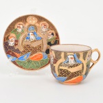 Belíssima xícara para café em cerâmica japonesa com decoração policroma, aplicação de moriage em relevo, realces em ouro e filete na borda. Apresenta composição figurativa formada por uma figura central sentada, acompanhada por quatro Imortais (sennin/rakan), representados como anciãos em trajes tradicionais, tema recorrente em produções de exportação em estilo Satsuma. O fundo do campo decorativo é preenchido por padrão de ondas, com áreas delimitadas por contornos dourados. O verso possui marca em losango contendo as iniciais JH e a inscrição MADE IN JAPAN, identificação utilizada na cerâmica japonesa de exportação a partir do início do século XX. A iconografia e a técnica de moriage situam a peça dentro da produção japonesa voltada ao mercado externo entre o final do período Taisho e o início do período Showa. Apresenta pequenos desgastes visíveis nas fotos, e um raso trincado no verso. Medidas:
