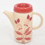 S.I.C. (Scuola Italiana Ceramica), Casale Monferrato - Itália. Elegante bule para café em majólica italiana da década de 1950/60; esmaltação vítrea de tonalidade creme, decorado com composição botânica manual em tom bordô, tampa circular removível, bico vertedor pronunciado, alça lateral em arco. Marca da manufatura ao fundo. Medida: Alt. 19,5 x Comp.: 21 x Larg.: 9 cm.