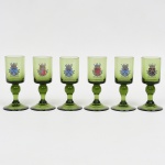 Conjunto de seis taças para licor em vidro, translúcido, tonalidade verde, bojo cilíndrico decorado  com brasões heráldicos esmaltado, identificando regiões. Composto de seis(06) unidades. Medidas: 