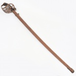 Sabre de cavalaria do Exército Argentino Modelo 1909, manufatura Weyersberg Kirschbaum & Cie., Solingen(fundada em 1584 em Solingen), Alemanha, início do século XX; lâmina curva em aço, dotada de canal longitudinal e ponta lanciforme, apresenta marca estampada com o escudo nacional da República Argentina e a inscrição SABLE DE CABALLERÍA  MODELO 1909, indicando o modelo regulamentar adotado pelo Exército Argentino no início do século XX. A base da lâmina conserva ainda a marca do fabricante WEYERSBERG KIRSCHBAUM & CIE  SOLINGEN, tradicional fabricante alemão de militaria situado na cidade de Solingen, centro histórico europeu da produção de espadas, sabres e baionetas. A montagem compreende guarda em ferro, punho revestido em material sintético estriado (baquelite ou composição similar) fixado por parafusos metálicos, e lâmina projetada para uso de cavalaria. Este modelo foi amplamente utilizado por unidades montadas do Exército Argentino durante a primeira metade do século XX, sendo parte das encomendas realizadas pelo país a fabricantes alemães especializados em armamento militar. Estado de conservação conforme fotografias, apresenta sinais de oxidação compatíveis com o tempo. Medida: Comp.: 105 cm.