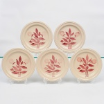 S.I.C. (Scuola Italiana Ceramica), Casale Monferrato - Itália. Elegante conjunto de pratos em majólica italiana da década de 1950/60; esmaltação vítrea de tonalidade creme, centro ligeiramente rebaixado, decorado com composição botânica manual em tom bordô, orla circundada por friso relevado na própria pasta. Composto de cinco(05) unidades. Marca da manufatura no verso. Medida: Diam.: