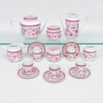 Porcelana Real, Mauá - SP(Fundada em 1943 por Fritz Erwin Schmidt). Conjunto em porcelana nacional, esmaltação branca, dotada de rica decoração em estampagem integralmente de tom rosáceo, composta de flores e folhagens distribuídas ao redor do bojo e tampa, bordas circundadas por faixa contendo folhagens imbricadas delimitado por friso de tonalidade mais intensa. Composto de um(01) bule para chá, um(01) bule para café, uma(01) leiteira, uma(01) cremeira, dois(02) potes com tampa e cinco(05) xícaras para café. Marca da manufatura ao fundo. Medidas: