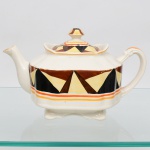 J & G Meakin, Staffordshire - Inglaterra(Fundada em 1851). Bule para chá em faiança inglesa da década de 1930, padrão "SOL". Formato quadrangular, de quinas levemente chanfradas, bordo recortado em ondulações, tampa ligeiramente abaulada, puxador com feitio de pião, alças lateral curvada, bico vertedor ondulado, base sobre pés recortados; esmaltação de tom marfim, dotado de rica decoração Art Déco, contendo composição geométrica radial, formada por reservas triangulares alternadas em esmalte de tonalidade preta, marrom e amarelo-creme, dispostas em sequência contínua, bojo circundado por frisos concêntricos em tom laranja e mostarda, este último se replica no contorno da borda da tampa. Marca da manufatura no verso. Medidas: Alt.:  x Comp.:  x Larg.:  cm. Estado de conservação conforme fotografias. Apresenta desgastes pontuais de uso, vide foto.