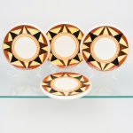 J & G Meakin, Staffordshire - Inglaterra(Fundada em 1851). Conjunto de descansos de travessa  em faiança inglesa da década de 1930, padrão "SOL". Formato circular, esmaltação de tom marfim, dotado de rica decoração Art Déco, contendo composição geométrica radial na aba, formada por reservas triangulares alternadas em esmalte de tonalidade preta, marrom e amarelo-creme, dispostas em sequência contínua. Centro circundado por frisos concêntricos em tom laranja e mostarda. Marca da manufatura no verso. Composto de quatro(04) unidades. Medida: Diam.: 17,5 cm. Estado de conservação conforme fotografias. Apresentam manchas do tempo e desgastes pontuais de uso.