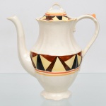 J & G Meakin, Staffordshire - Inglaterra(Fundada em 1851). Bule para café em faiança inglesa da década de 1930, padrão "SOL". Bojo de perfil balaústre, bordo recortado em ondulações, tampa ligeiramente abaulada, puxador em arco, alça lateral curvada, bico vertedor curvilíneo, base circular recortada; esmaltação de tom marfim, dotado de rica decoração Art Déco, contendo composição geométrica radial, formada por reservas triangulares alternadas em esmalte de tonalidade preta, marrom e amarelo-creme, dispostas em sequência contínua, bojo circundado por frisos concêntricos em tom laranja e mostarda, este último se replica no contorno da borda da tampa. Marca da manufatura no verso. Medidas: Alt.:  x Comp.:  x Larg.:  cm. Estado de conservação conforme fotografias. Apresenta desgastes pontuais de uso, vide foto.