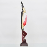 Escultura balinesa representando figura feminina, executada em madeira policromada e realces dourados. Apresenta trincado no queixo. Demanda pequeno resaturo. Medidas: Alt.: 54 x Comp.: 8,5 x Larg.: 9 cm.
