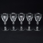 Belíssimo conjunto de taças de pé alto, para ....., executado em cristal europeu, diáfano e incolor; bojo obcônico, borda ligeiramente evertida, gravado com flores e faixa contínua de motivo vegetalista , haste tubular com anel intermediário e base circular. Composto de cinco(05) unidades. Medidas: Alt.: x Diam.:
