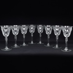 Belíssimo conjunto de taças de pé alto, para ....., executado em cristal europeu, diáfano e incolor; bojo obcônico, borda ligeiramente evertida, gravado com flores e faixa contínua de motivo vegetalista , haste tubular com anel intermediário e base circular. Composto de oito(08) unidades. Medidas: Alt.: x Diam.: