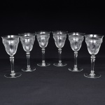 Belíssimo conjunto de taças de pé alto, para ....., executado em cristal europeu, diáfano e incolor; bojo obcônico, borda ligeiramente evertida, gravado com flores e faixa contínua de motivo vegetalista, haste tubular com anel intermediário e base circular. Composto de seis(06) unidades. Medidas: Alt.: x Diam.: