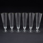 Conjunto de tulipas em meio cristal, diáfano e incolor, de bojo obcônico, alongado, sobre base circular. Composto de seis(06) unidades. Medidas: