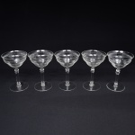 Belíssimo conjunto de taças de pé alto, para champanhe, executado em cristal europeu, diáfano e incolor; bojo campaniforme, borda ligeiramente evertida, gravado com flores e faixa contínua de motivo vegetalista , haste tubular com anel intermediário e base circular. Composto de cinco(05) unidades. Medidas: Alt.: x Diam.: