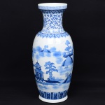 Grande vaso executado em porcelana, corpo oval alongado com gargalo em trompa e boca alargada, assentado sobre base circular, em estilo oriental inspirado na porcelana chinesa de exportação, com repertório paisagístico de tradição Ming/Qing. Decoração em azul sob vidrado, executada por pintura manual, representando paisagem com elementos arquitetônicos de inspiração oriental, incluindo pavilhões, pontes, embarcações e formações rochosas, distribuídos em campo contínuo; gargalo com motivos vegetalistas estilizados e borda com friso geométrico em padrão grego. Faixa inferior com elementos repetitivos em cartelas verticais. Medidas: Alt.: 64 x Diam.: 84 cm.