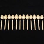 Belíssimo conjunto de colheres grandes confeccionadas em metal, dotadas de profusa ornamentação em douradura; lâmina com dorso serilhado, cabo relevado com decoração geométrica repetitiva em recortes simétricos losangulares e formas estilizadas, inseridos em campo texturizado. Fabricação coreana, marca da manufatura no verso. Composto de doze(12) unidades. Med.: Comp. 18 cm.