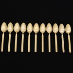 Belíssimo conjunto de colheres para sobremesa confeccionadas em metal, dotadas de profusa ornamentação em douradura; lâmina com dorso serrilhado, cabo relevado com decoração geométrica repetitiva em recortes simétricos losangulares e formas estilizadas, inseridos em campo texturizado. Fabricação coreana, marca da manufatura no verso. Composto de doze(12) unidades. Med.: Comp. 15,5 cm.