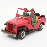 BRINQUEDO ANTIGO. Viatura de bombeiros  confeccionado em folha-de-flandres litografada, com mecanismo elétrico a pilhas. Carroceria em metal estampado e litografado, com pintura predominantemente vermelha e inscrição frontal FIRE DEPT No. 5. Interior com duas figuras de bombeiros com braços articulados, uniformes na tonalidade verde e capacetes vermelhos. Detalhes como grade frontal vazada, para-choques metálicos, estepe traseiro e volante funcional. Base metálica com compartimento para pilhas e motor elétrico, acionado por chave seletora ON/OFF na parte inferior. Produção japonesa, fabricada pela NOMURA Nomura, circa década de 1950/1960. Estado de conservação com perdas de policromia, oxidação na base e componentes metálicos, desgaste geral e sinais de uso compatíveis com a idade, com funcionamento não testado, sem garantias de funcionamento, braços dos personagens necessitam ajuste e restauro. Medidas: Alt.: 14 x Comp.: 27 x Larg.: 12 cm.