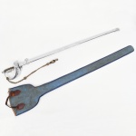 MILITARIA. AEC  Abramo, Eberle & Co. Espada de apresentação, padrão cerimonial, com lâmina reta em aço polido, seção plana e ponta aguda, acompanhada de bainha metálica niquelada. Empunhadura integralmente metálica, com guarda em arco (tipo meia-lua) e concha decorada aplicada com o emblema da República dos Estados Unidos do Brasil, contendo a inscrição 15 de Novembro de 1889. Talabarte em cordão têxtil trançado, com nós decorativos e terminal, destinado à fixação em uniforme de gala. Apresenta perda da empunhadura, vide fotos. Acompanha capa confeccionada em tecido. Medida: Comp.: 100 cm.