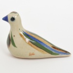 Escultura animalista executada em cerâmica, representando de pássaro, característica do artesanato folclórico mexicano de Tonalá. Corpo de forma alongada, com base plana e orifício inferior de ventilação. Bico curto, olhos aplicados e cauda afilada. Decoração em esmalte policromo, com faixas longitudinais em azul, verde e ocre, além de aplicação lateral com motivo vegetalista. Medidas: Alt.: 9 x Comp.: 15 x Larg.: 6 cm.